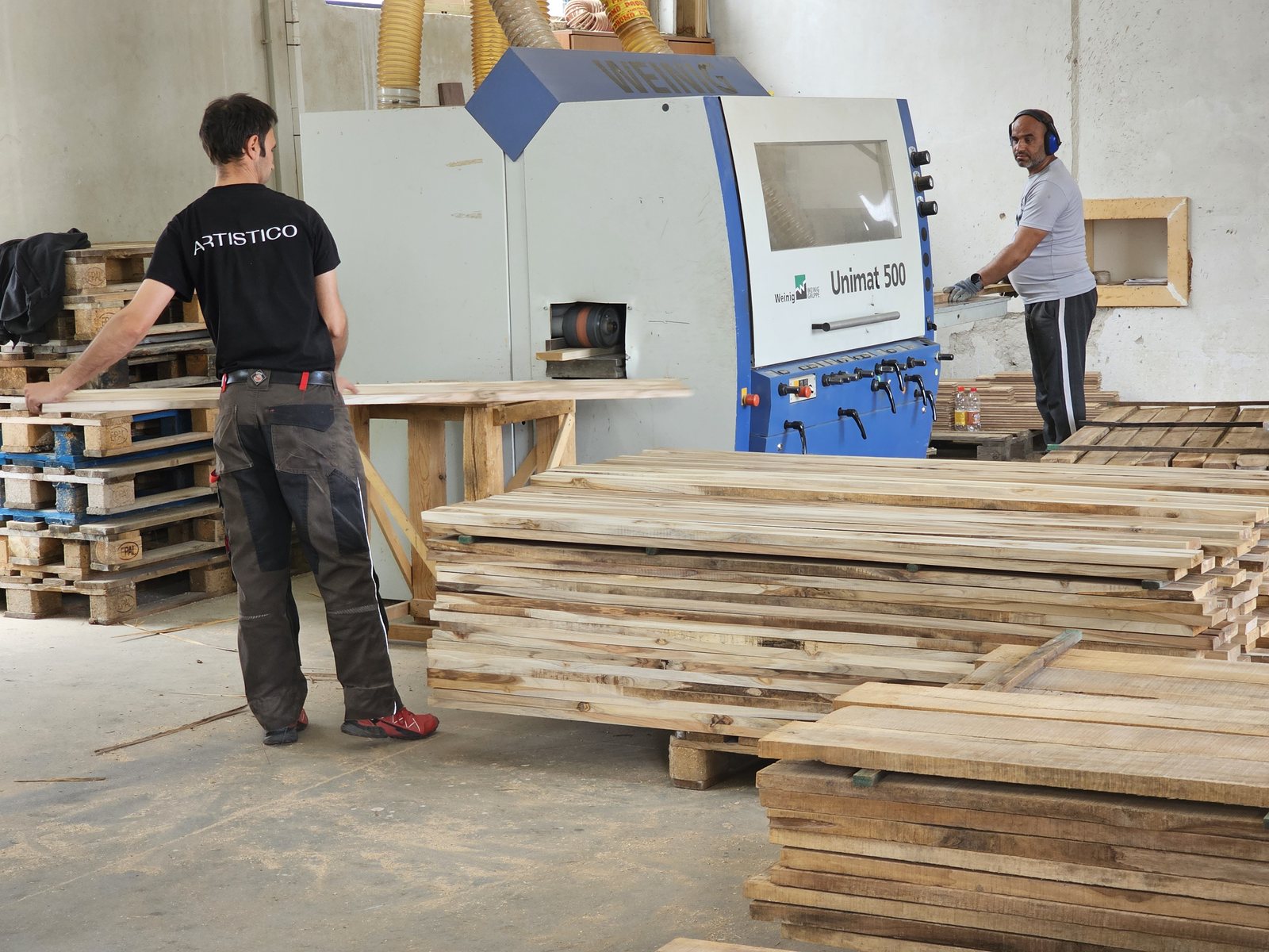 Two craftsmen feeding oak material into a Weinig Unimat 500 moulder