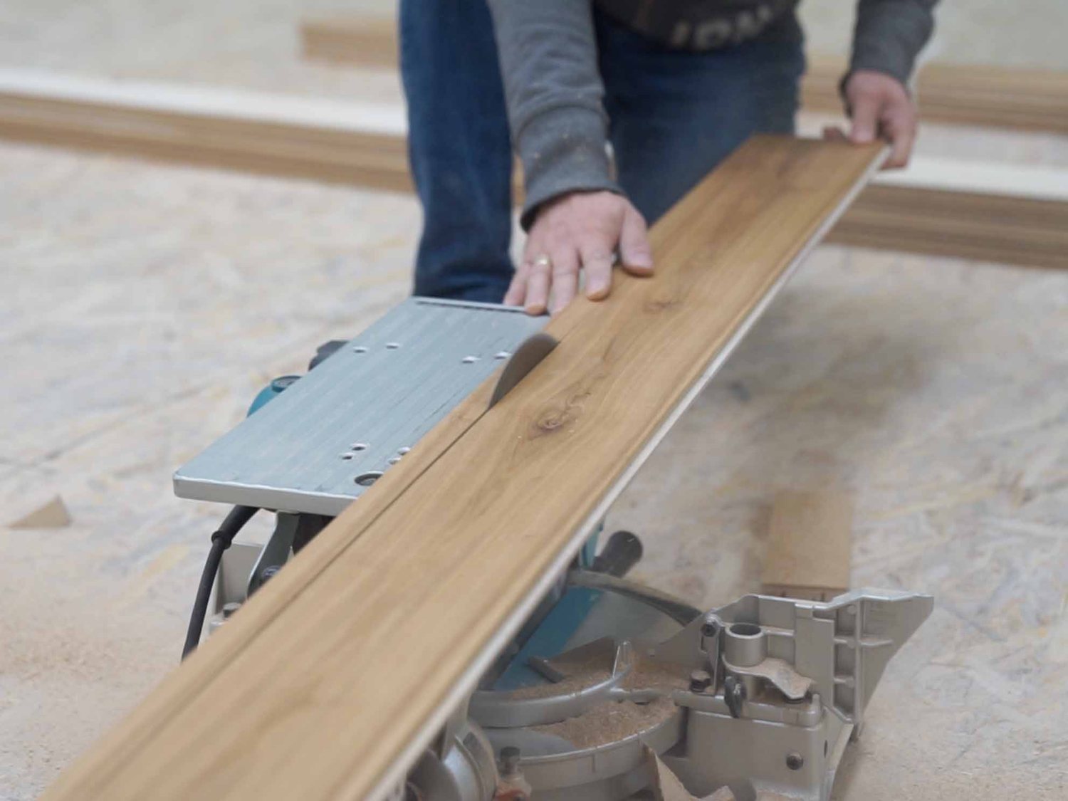 A craftsman’s hands guiding an oak board on site